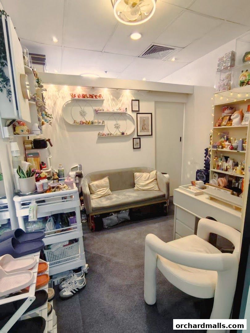 Interior of a beauty shop with shelves of products, a sofa, and a chair.