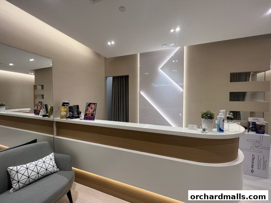The reception area of The Chelsea Clinic features a modern counter with products and a comfortable waiting sofa.
