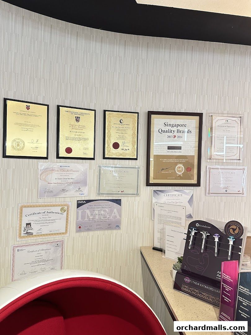 Wall adorned with certificates and awards, with medical aesthetic products displayed on a counter.