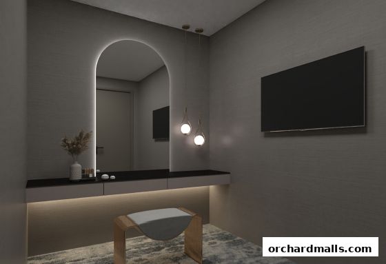 A modern vanity area with a large arched mirror, soft lighting, and a stylish stool.