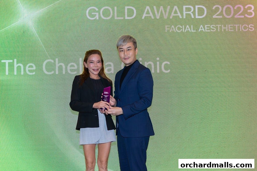 Two people holding an award with "The Chelsea Clinic" and "Facial Aesthetics" text.