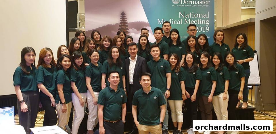 A group of people, likely staff, posing for a photo at a Dermaster event.