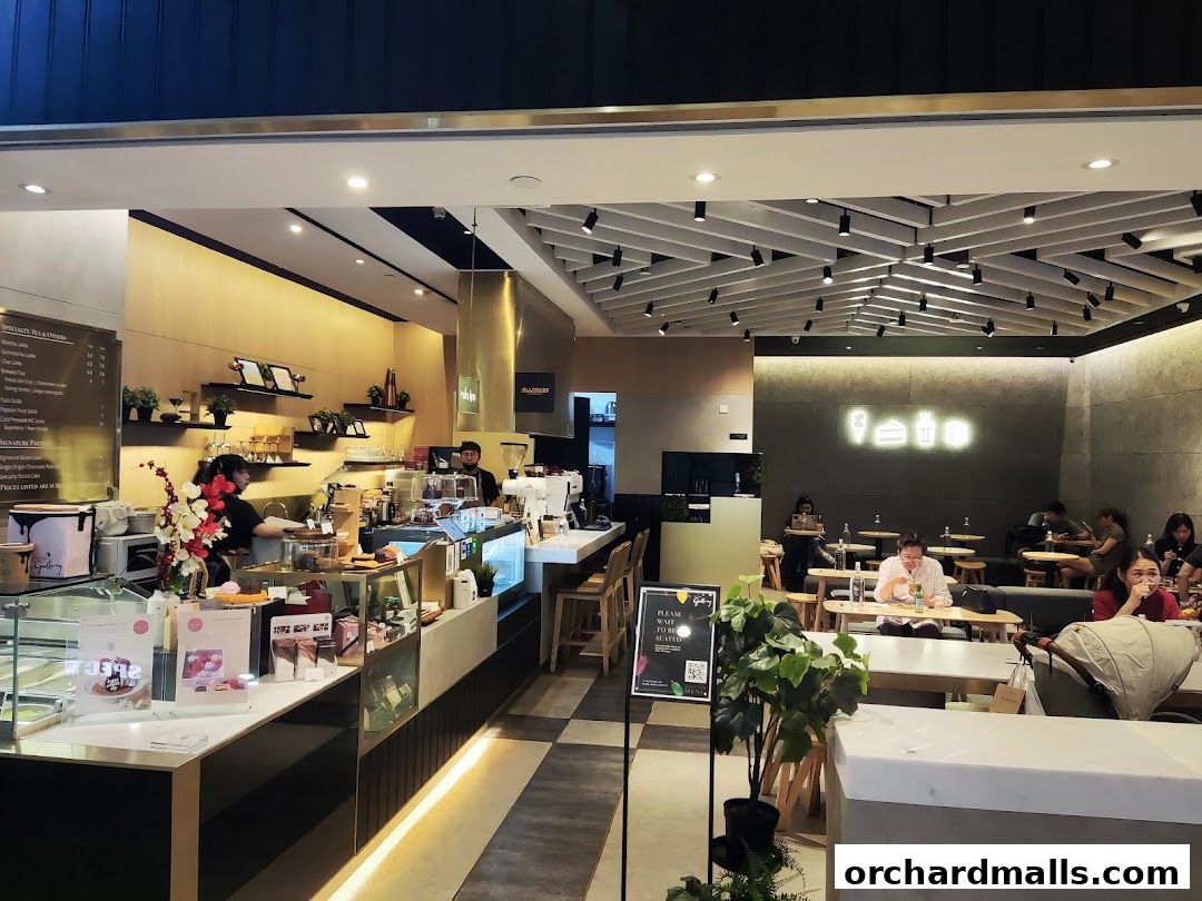 Interior view of a modern cafe with a counter, seating area, and neon sign.