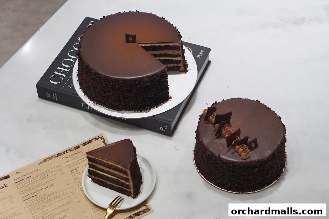Decadent chocolate cakes and a slice of cake displayed on a marble surface.