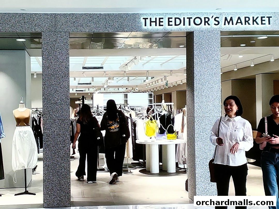 The entrance to THE EDITOR'S MARKET clothing store with mannequins and racks of clothes visible.