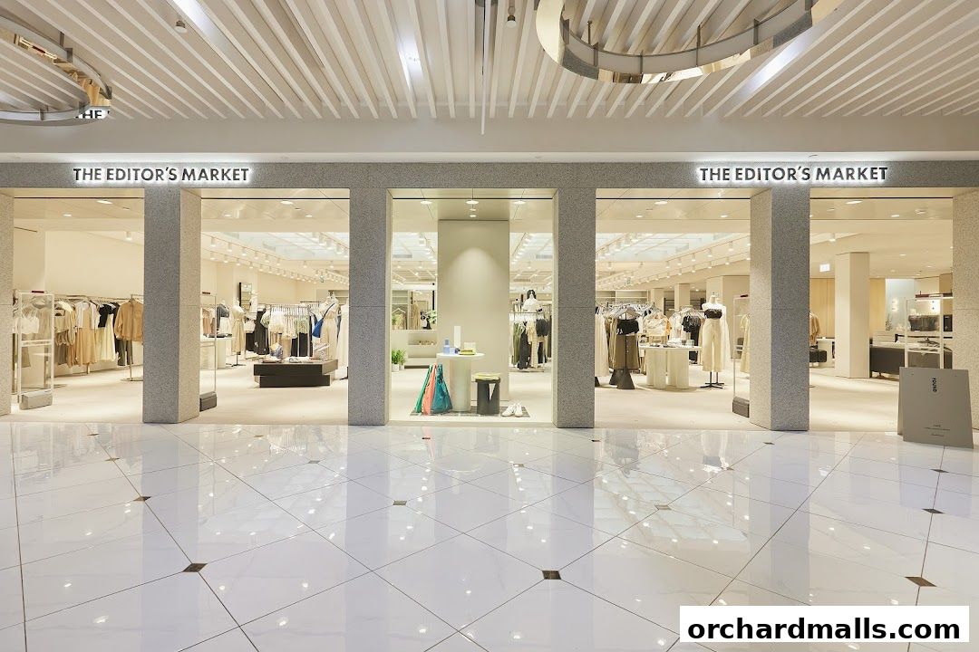 The entrance of THE EDITOR'S MARKET clothing store, showcasing stylish apparel on racks.