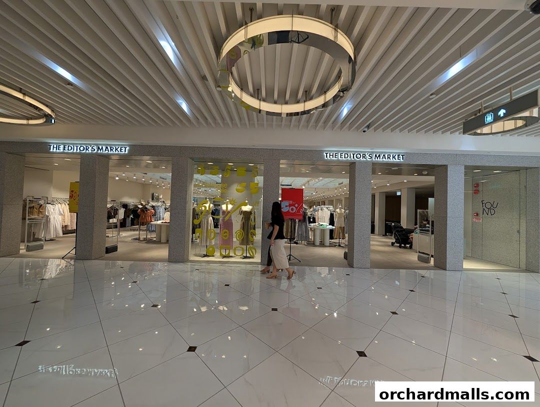 The entrance of THE EDITOR'S MARKET clothing store with mannequins and clothing displays.