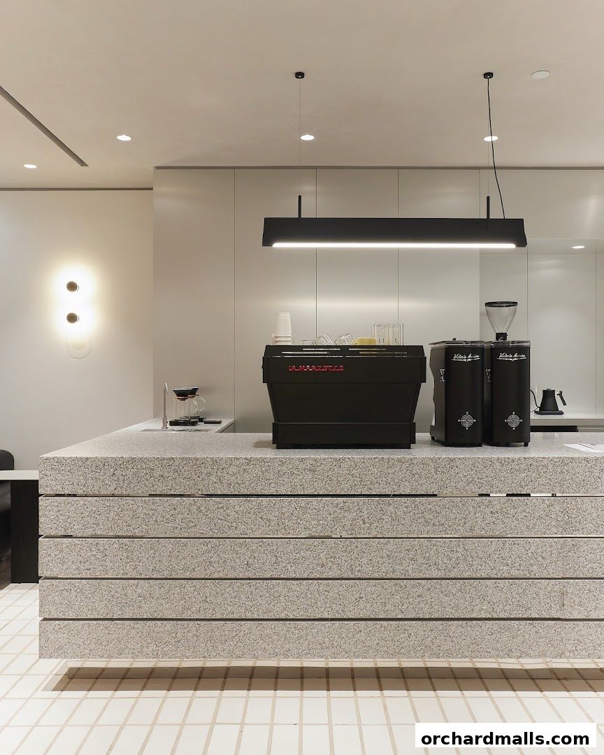 Modern coffee bar with espresso machine, grinders, and pour-over setup.
