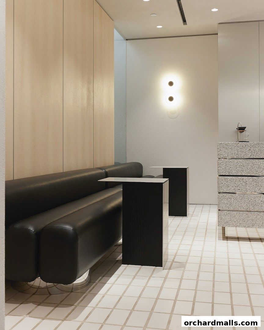 Modern interior with a black leather sofa, minimalist tables, and a speckled counter.