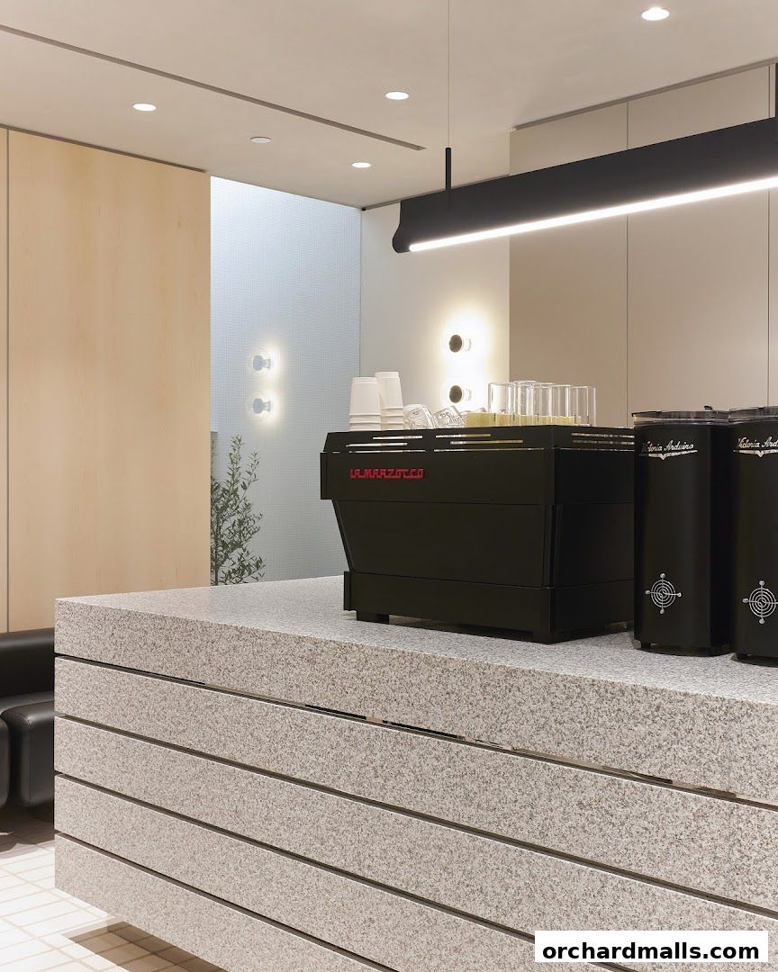 A modern coffee counter with a La Marzocco espresso machine and grinders.