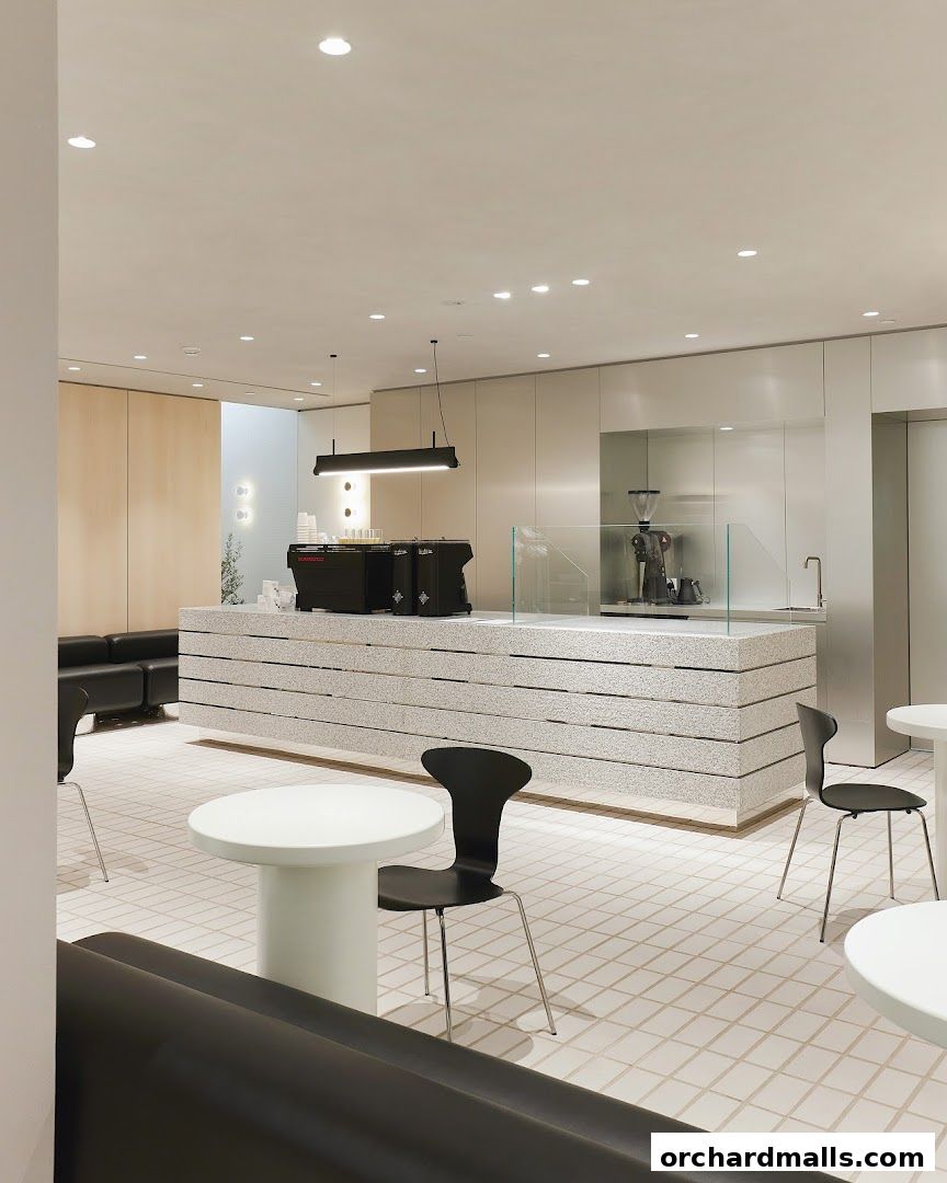 Modern coffee shop interior with a sleek counter, seating, and espresso machines.