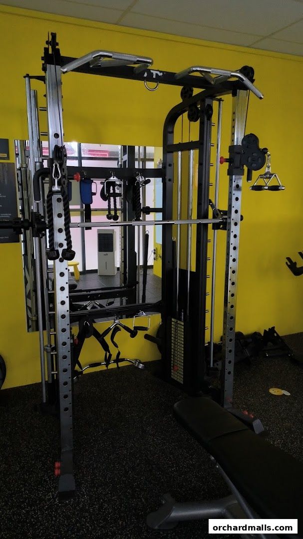A multi-functional gym machine with various attachments and a weight bench.