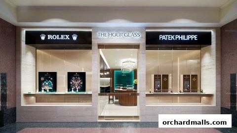 The Hour Glass luxury watch retailer featuring Rolex and Patek Philippe displays.