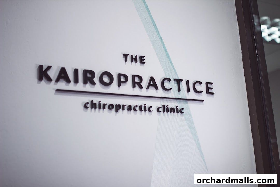 The KAIRO PRACTICE chiropractic clinic sign on a white wall with a subtle design.