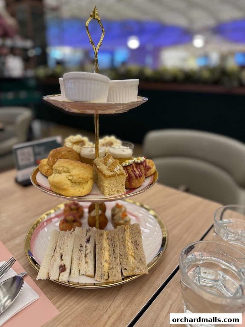 A three-tiered stand filled with assorted sandwiches, scones, pastries, and desserts.