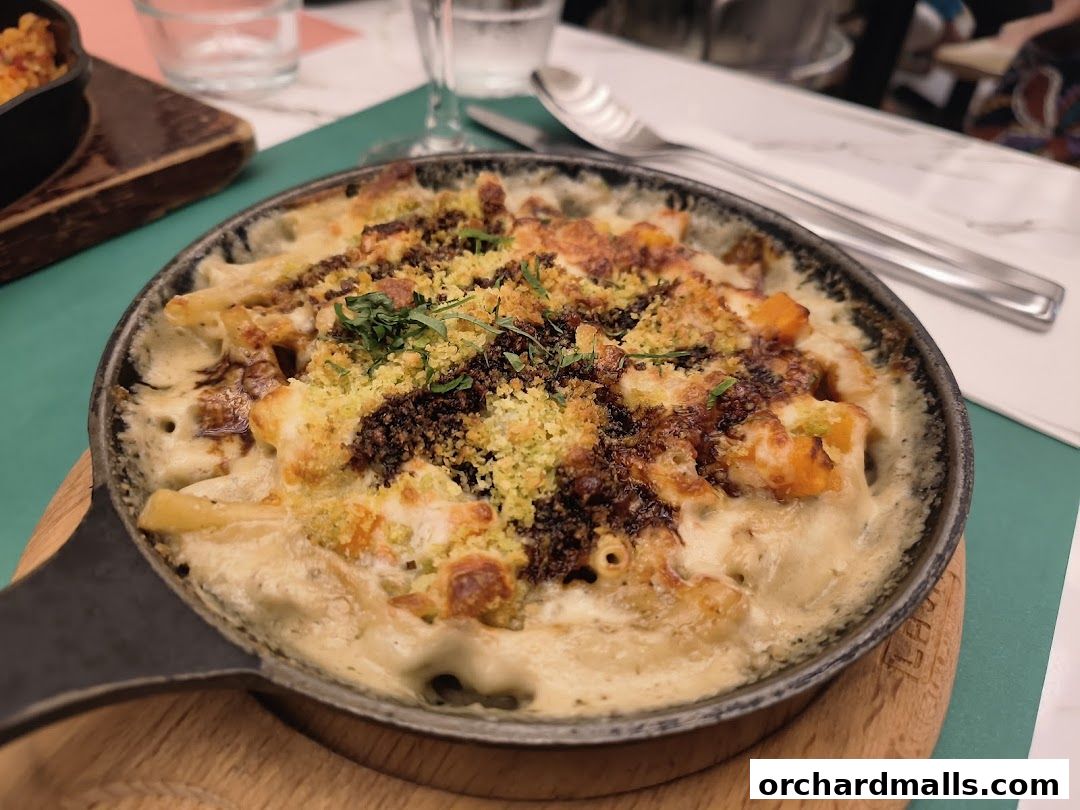 A close-up shot of a baked pasta dish with a crispy topping in a cast-iron skillet.