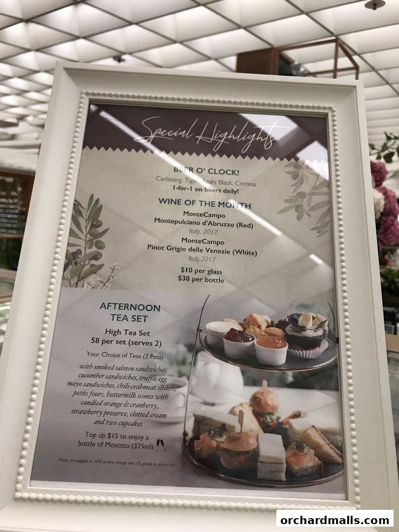 A framed menu board showcasing special highlights including beer offers and an afternoon tea set.