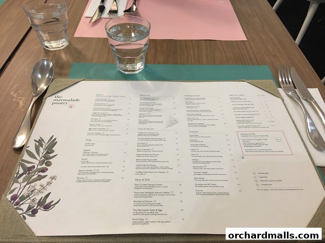A table setting with two glasses of water and a menu from The Marmalade Pantry.