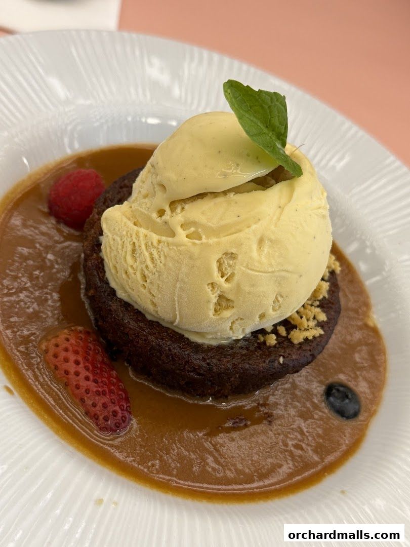 A decadent chocolate dessert with vanilla ice cream, caramel sauce, and fresh berries.
