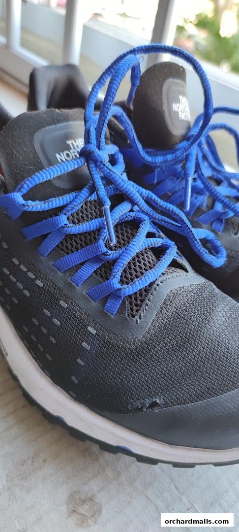 Close-up of black North Face sneakers with bright blue laces.