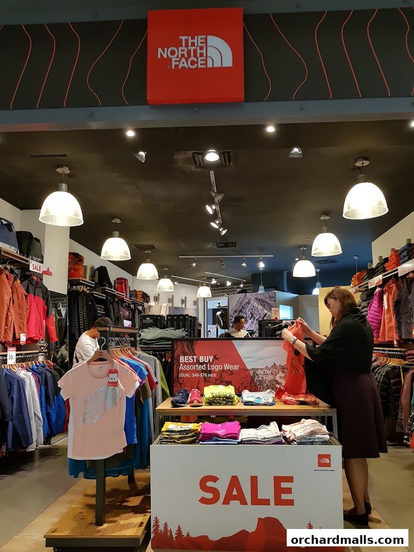 Interior view of The North Face store with clothing racks and a sale display.