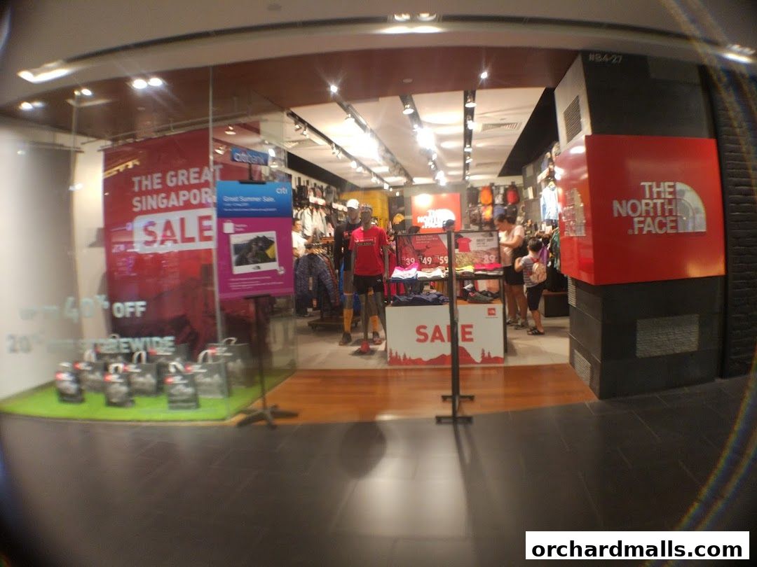 The North Face store entrance with sale banners and merchandise displayed inside.