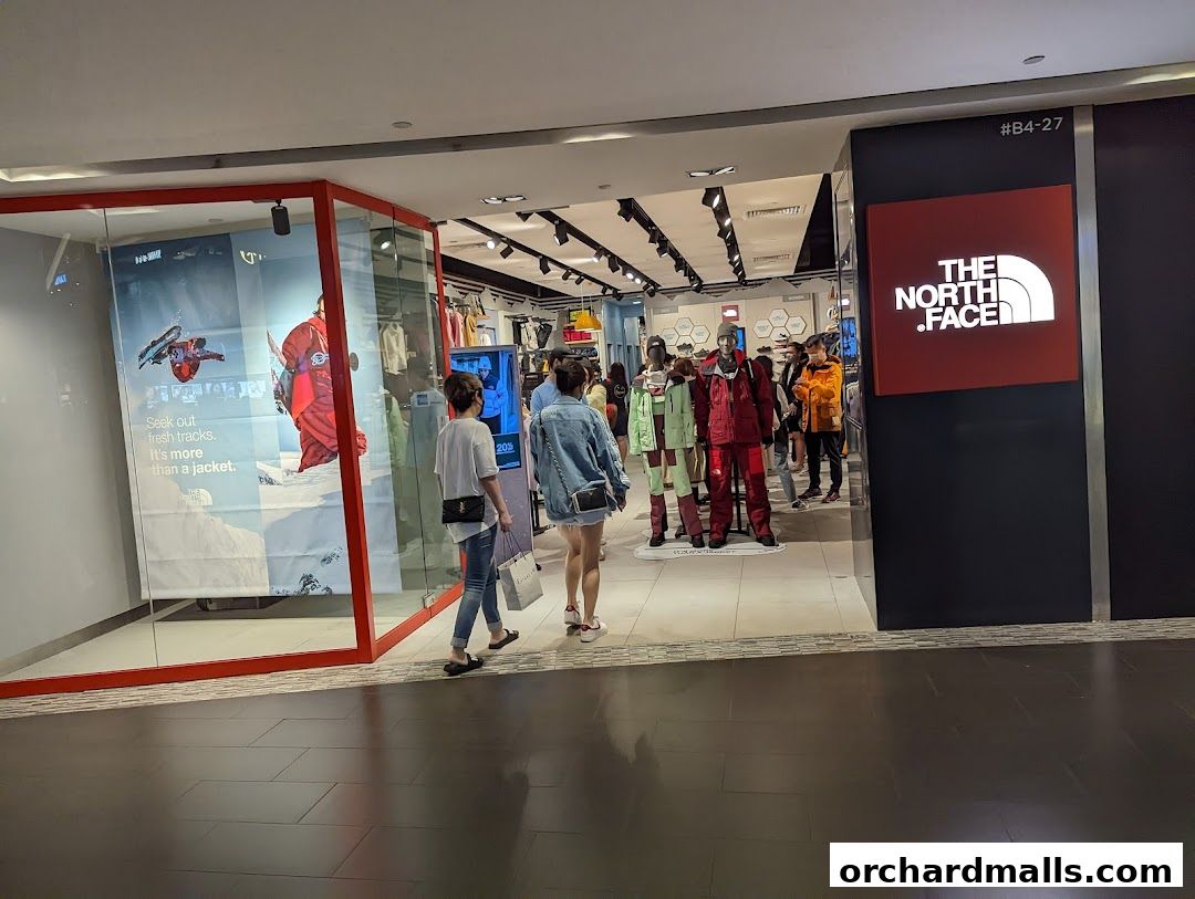 The North Face store entrance with mannequins displaying jackets and a promotional poster.