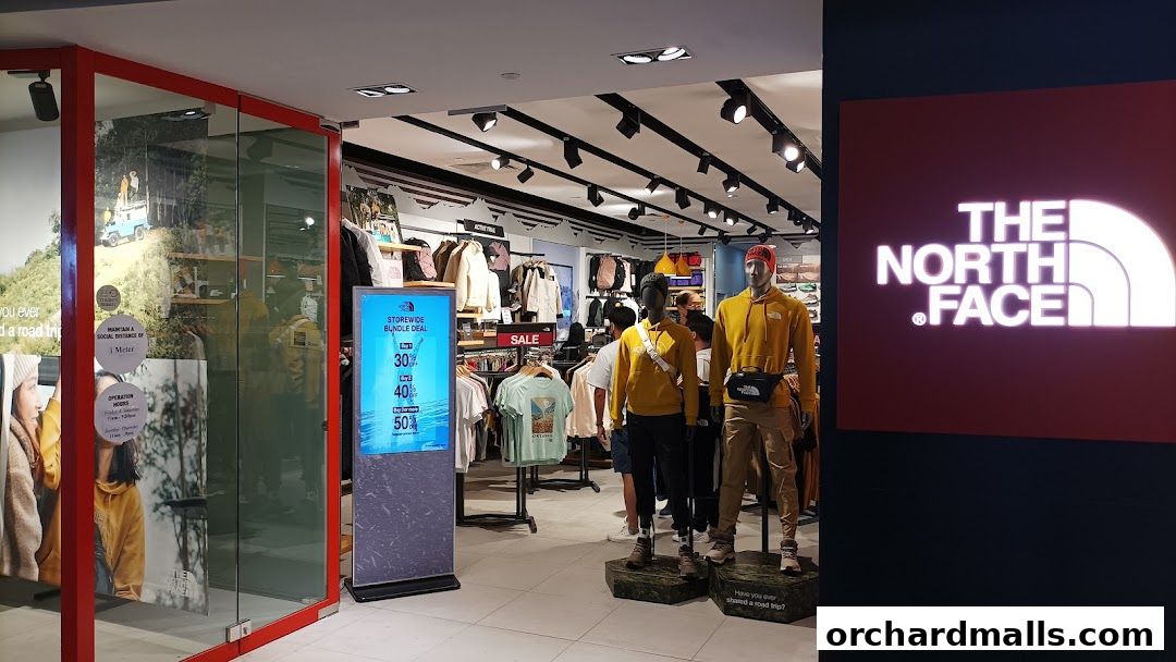 The North Face store interior with mannequins, clothing displays, and promotional signage.