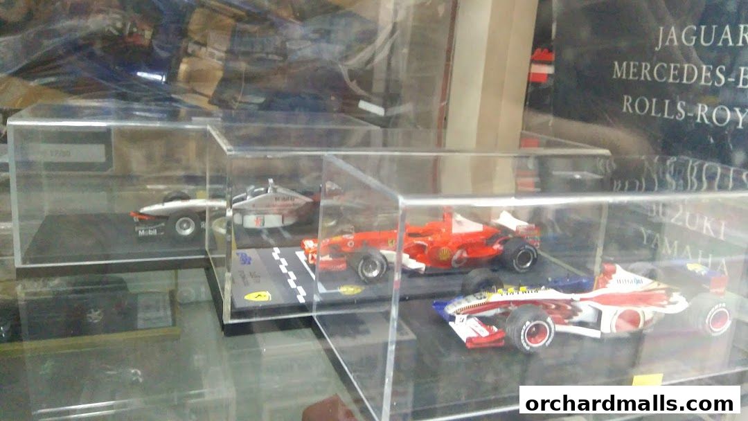 Display of detailed model race cars in clear protective cases.