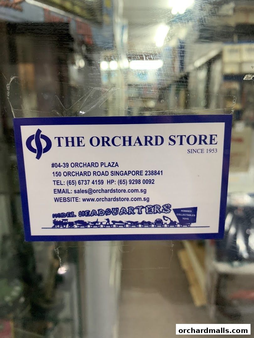 A sticker on a glass door for The Orchard Store, a hobby and collectibles shop.