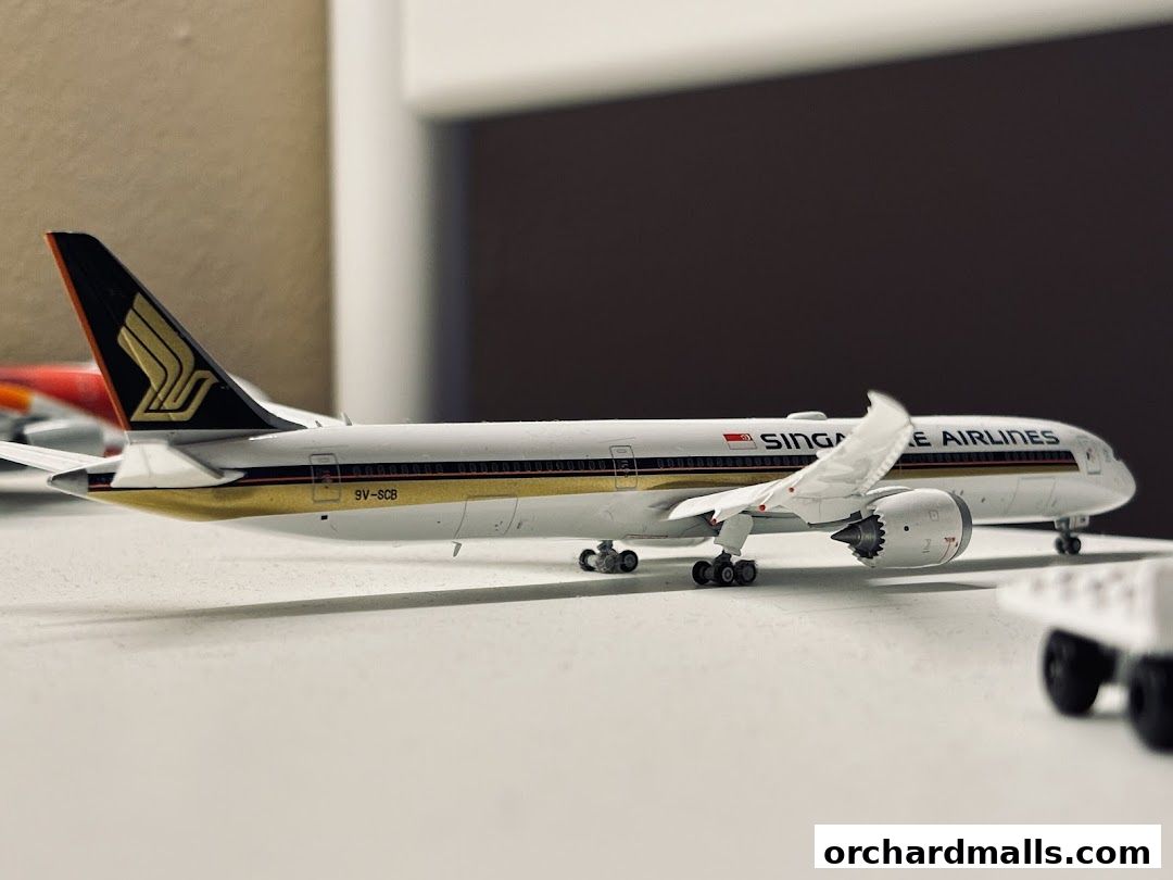 A detailed model of a Singapore Airlines airplane with gold accents and the airline's logo.