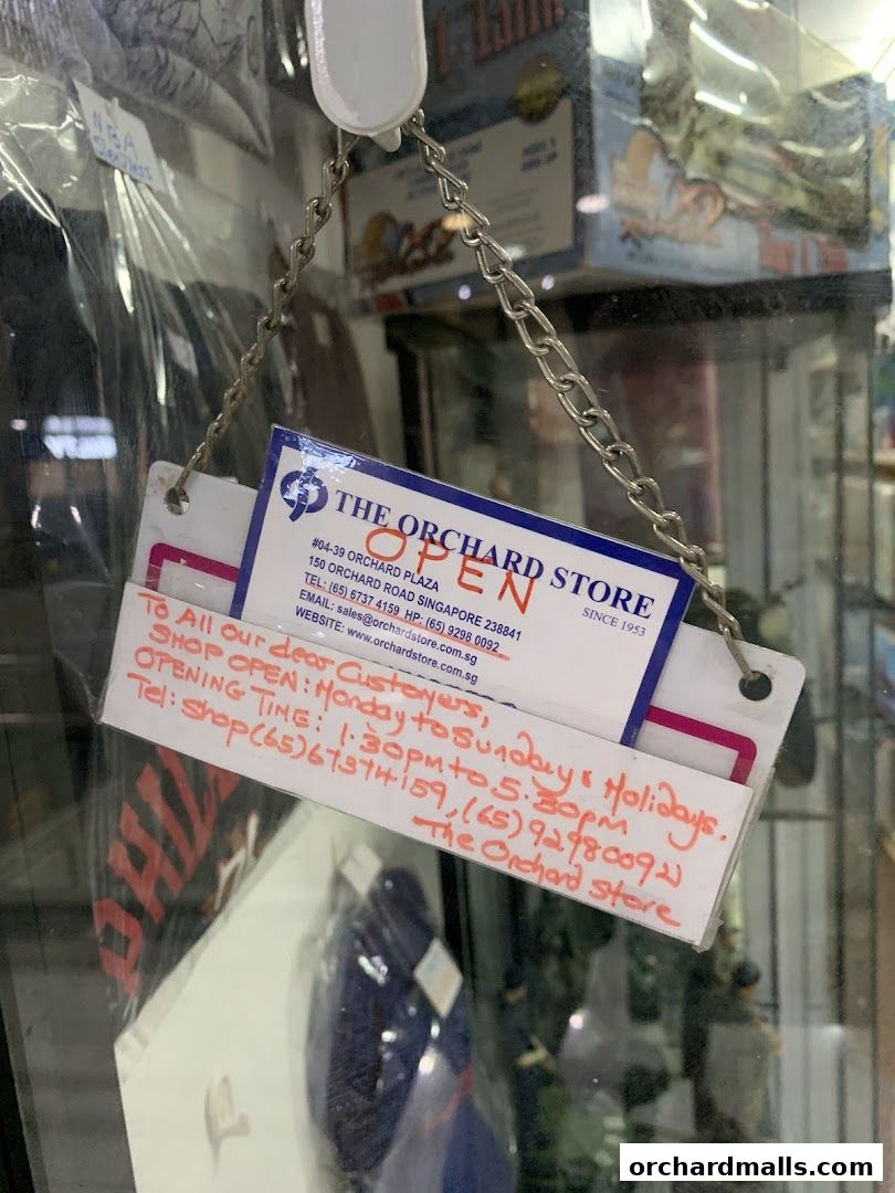 A sign for The Orchard Store indicating it is open with operating hours and contact details.