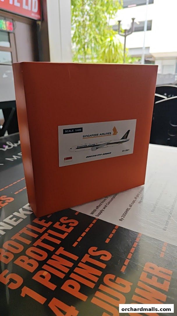 A Singapore Airlines model airplane in a box, displayed on a table.