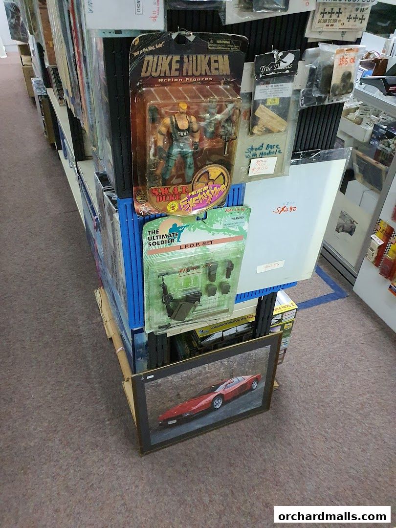 Display of collectible action figures and framed art in a retail store.