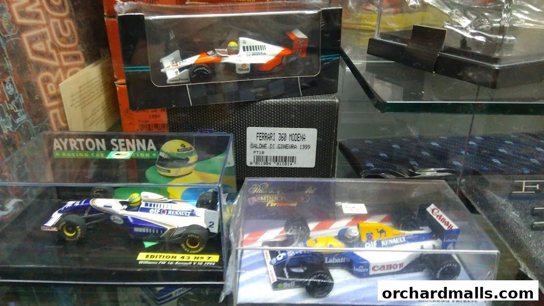 Display of collectible model race cars, including Ayrton Senna and Ferrari.