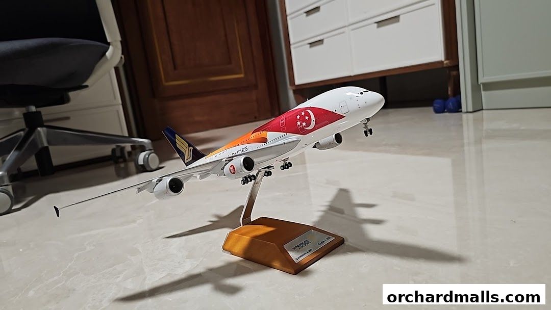 A detailed model airplane of Singapore Airlines Airbus A380 on a wooden stand.