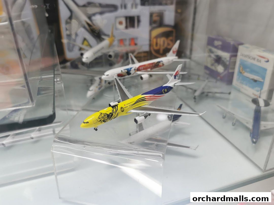 A display case filled with various detailed model airplanes, including a prominent Malaysian Airlines model.