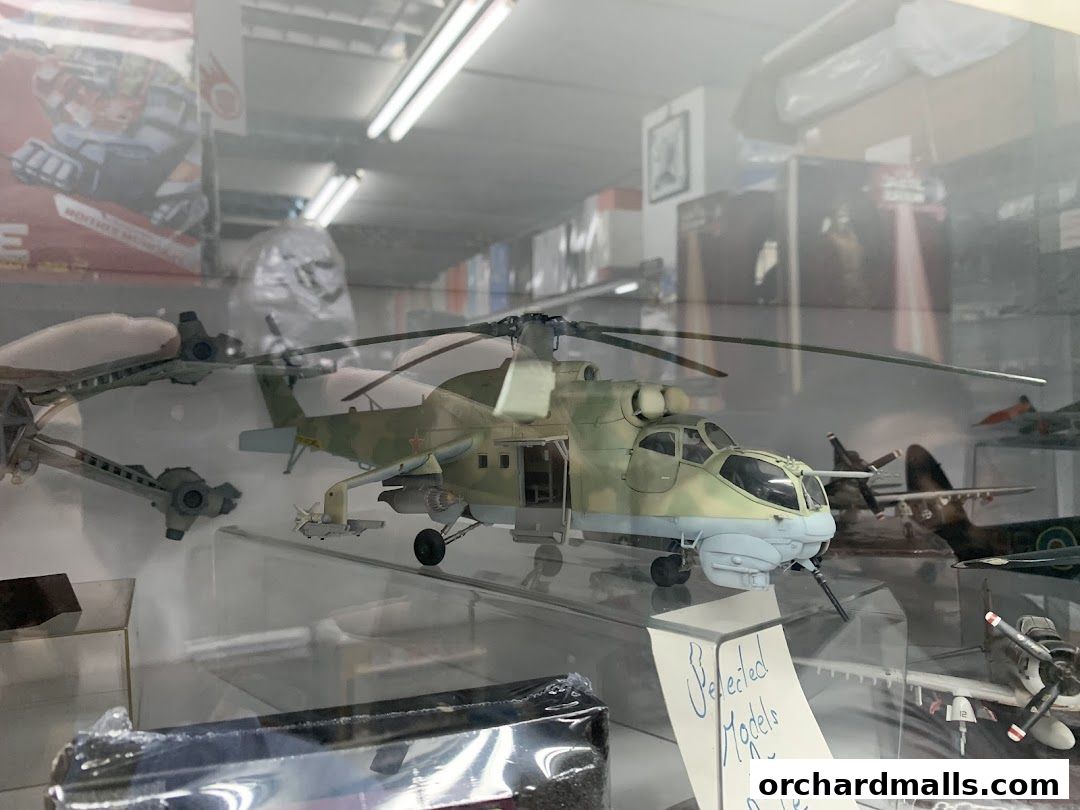 A display case filled with detailed model aircraft and helicopters, including a prominent military helicopter.