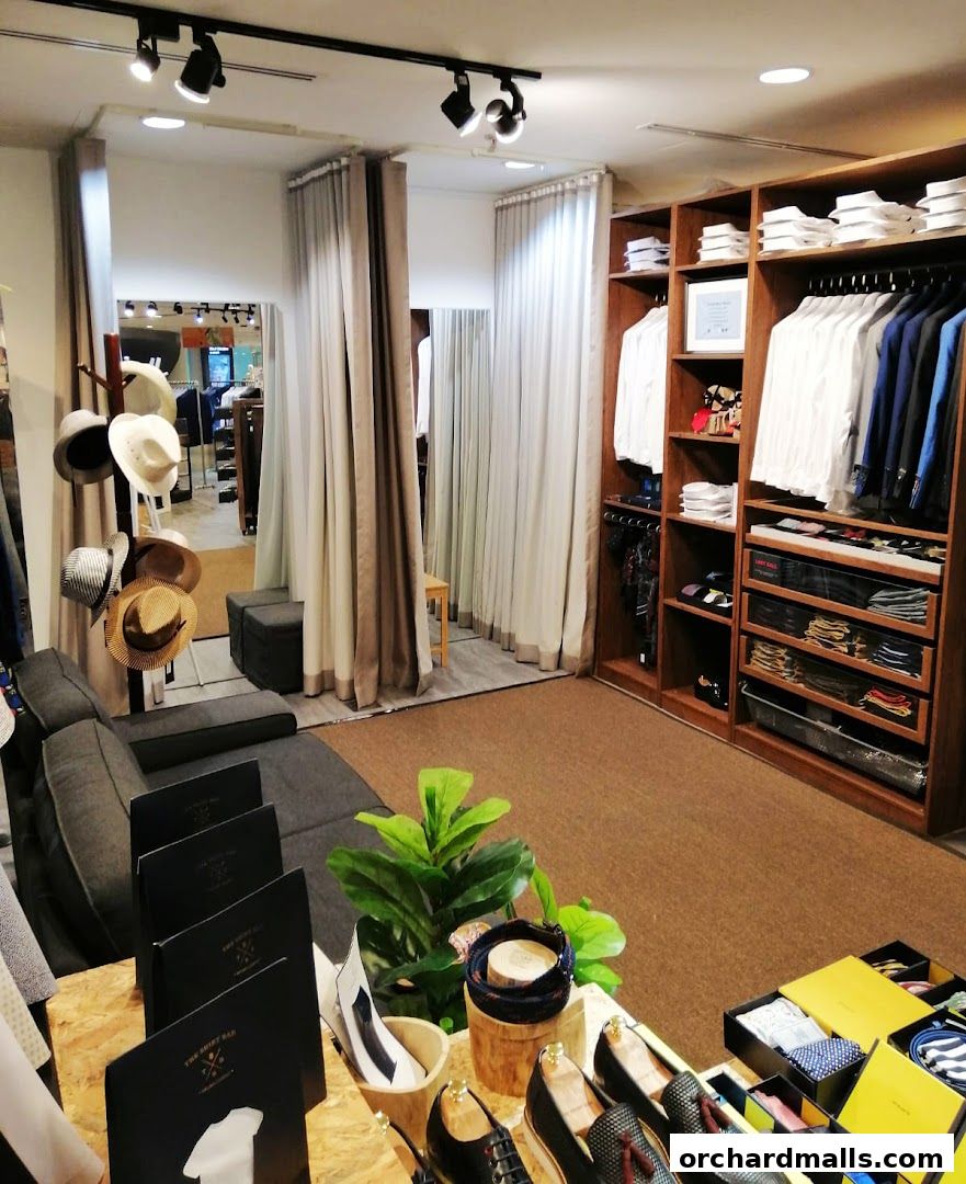 Interior of a men's clothing store featuring shirts, suits, hats, and shoes.