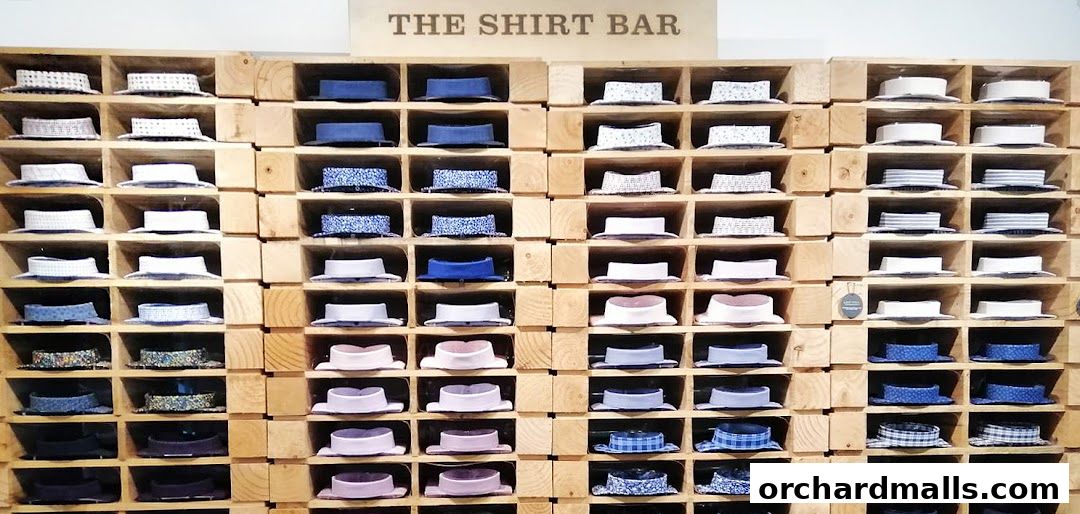 A wall display of folded shirts in wooden cubbies at The Shirt Bar.