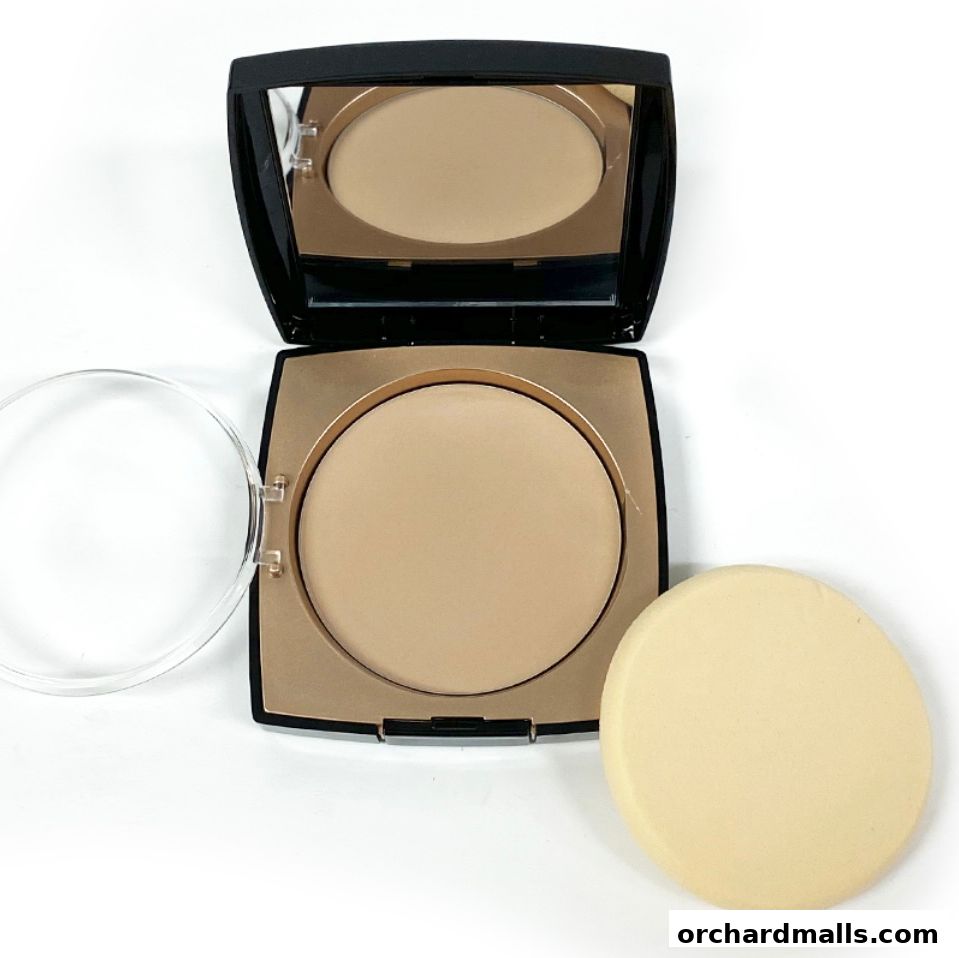 A compact powder foundation with a mirror and applicator on a white background.