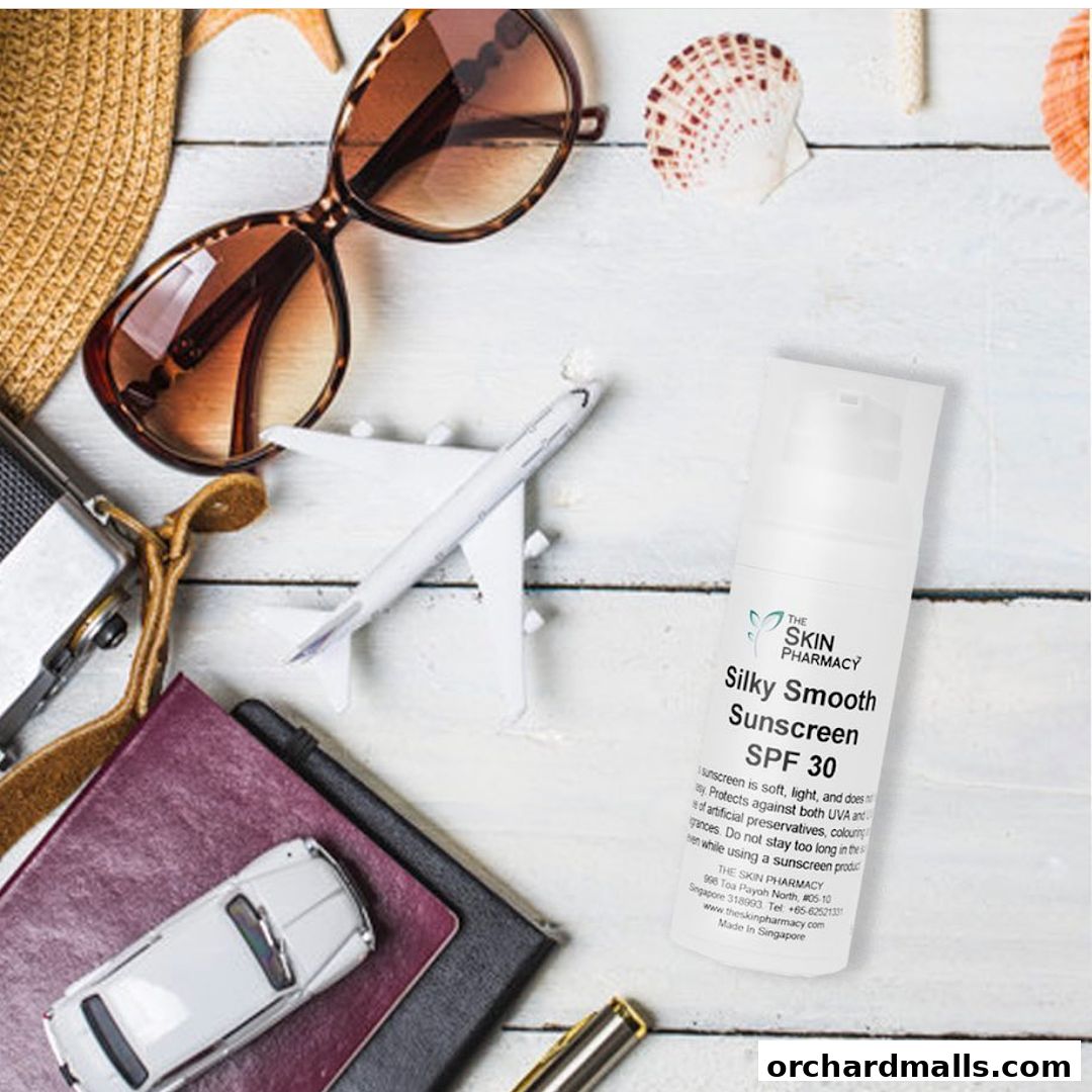 Travel essentials including sunscreen, sunglasses, passport, and toy car on a white wooden surface.