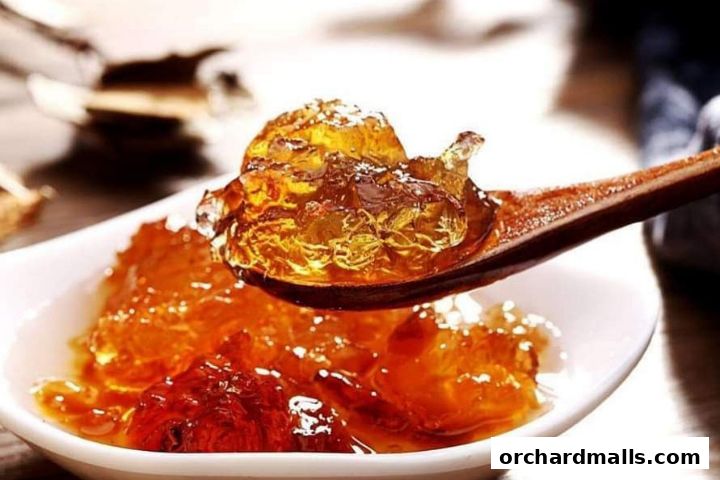 A close-up shot of a spoonful of amber-colored jelly dessert with a textured appearance.