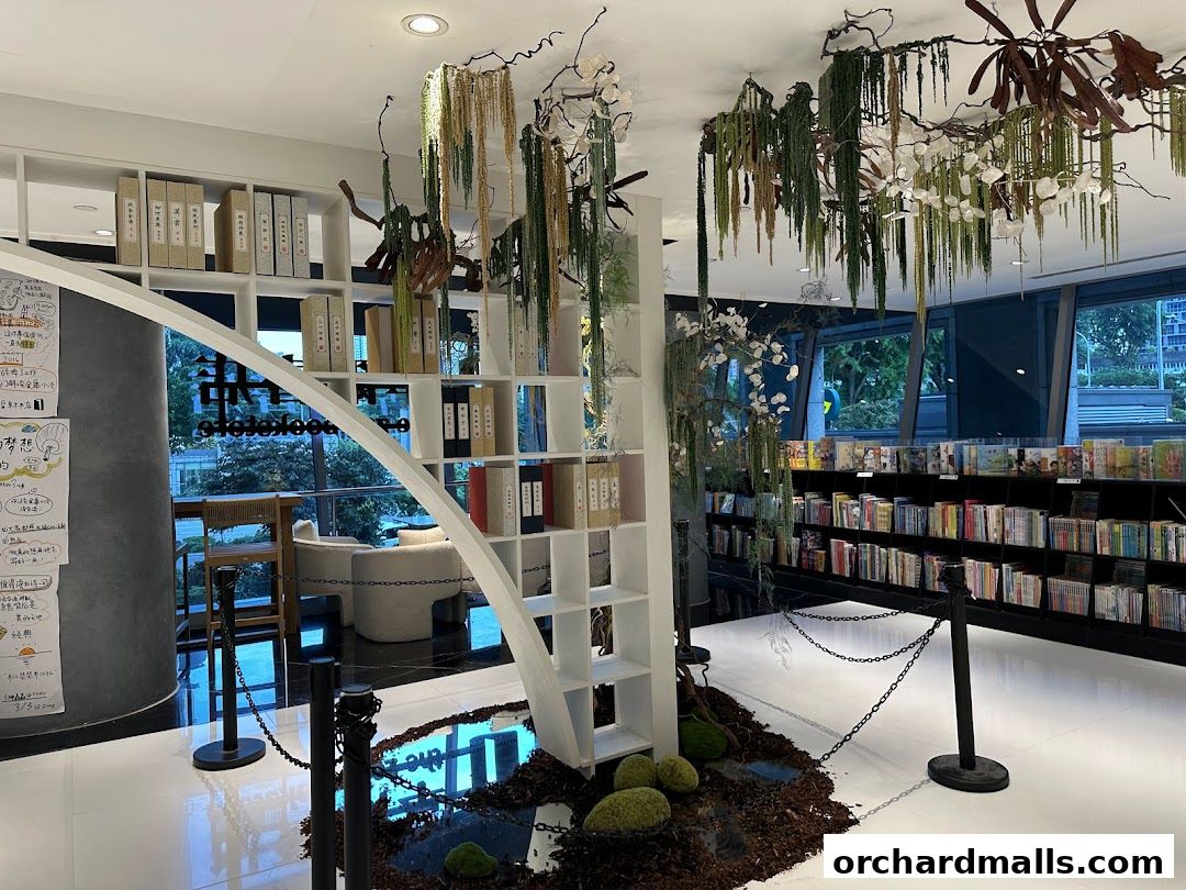Interior of a modern bookstore with shelves of books, decorative plants, and seating areas.