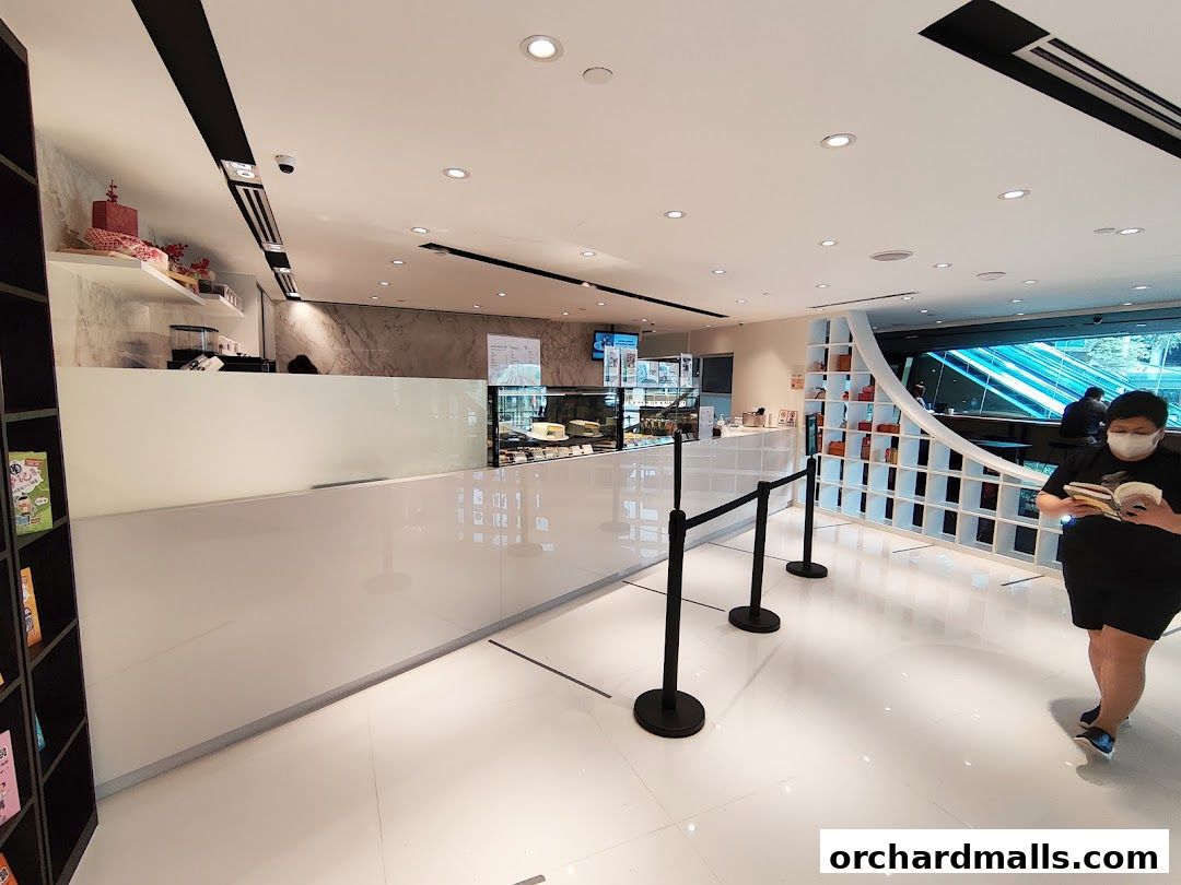 Interior of a modern bookstore with a cafe counter and display shelves.