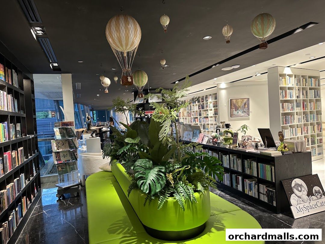 Interior of a modern bookstore with bookshelves, plants, and hot air balloon decorations.