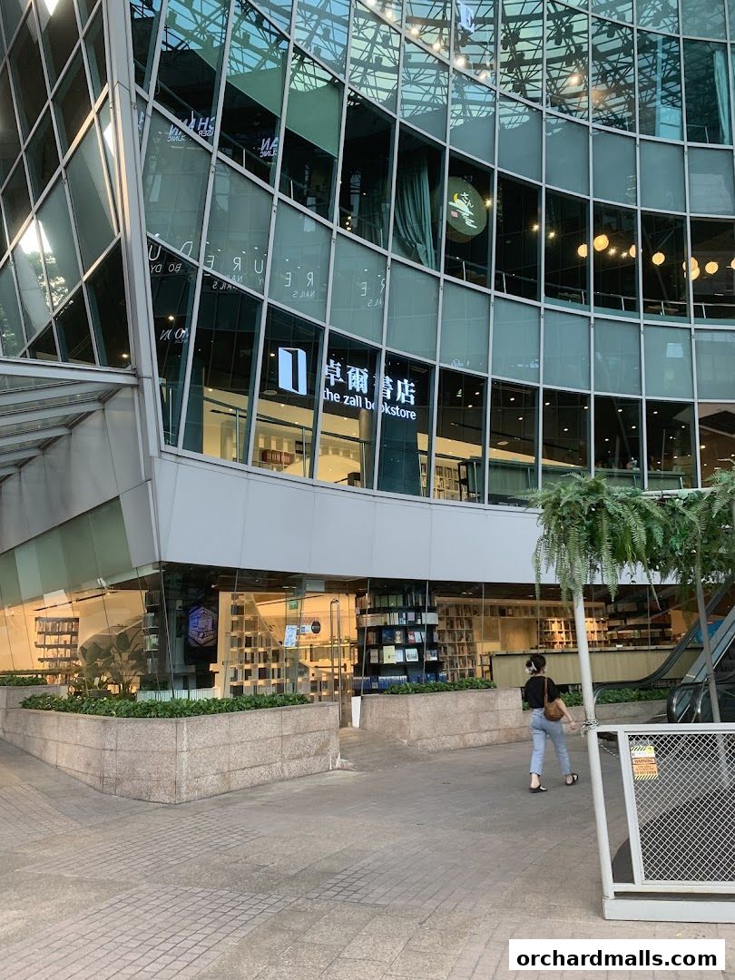 The Zall Bookstore entrance with books displayed inside and a person walking by.
