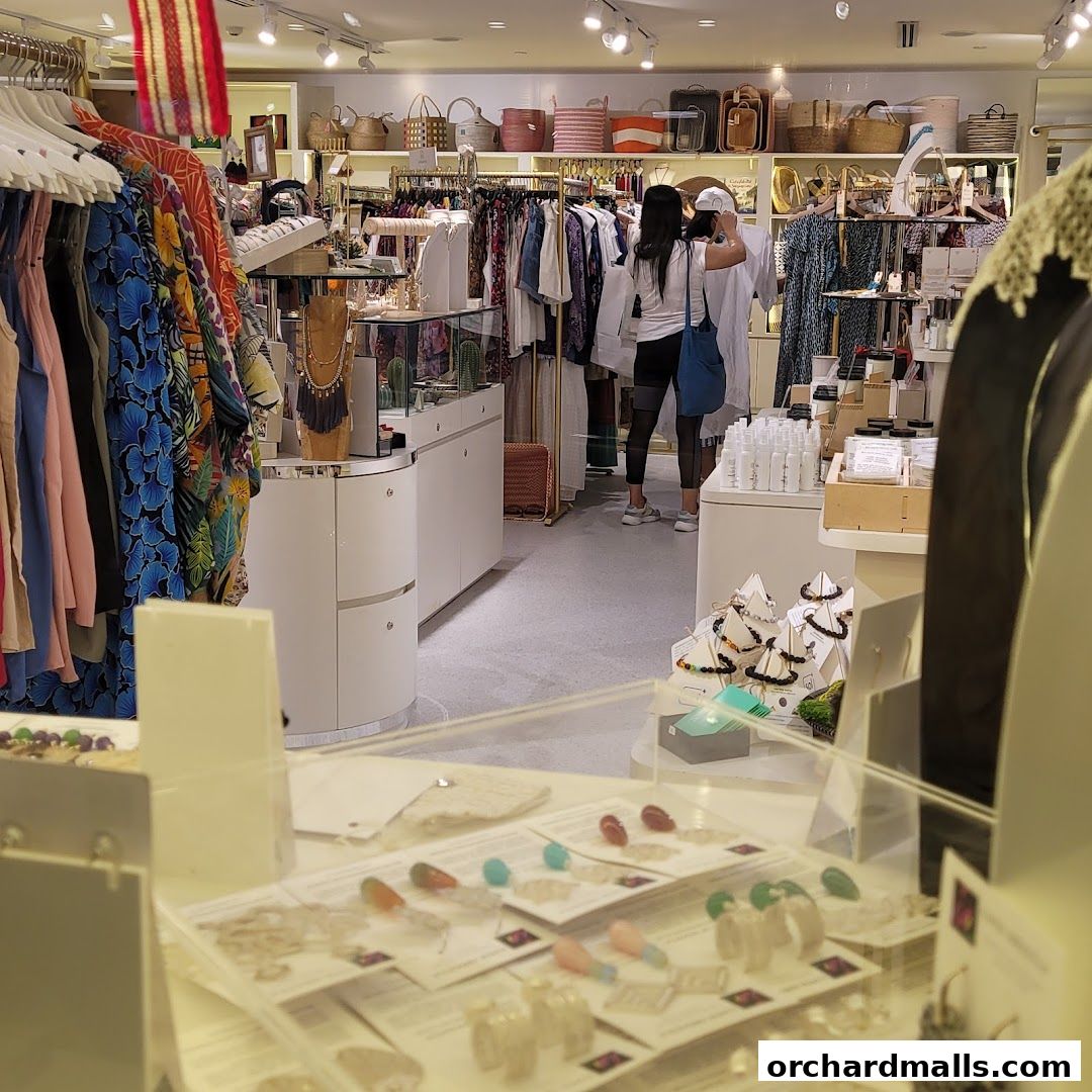 Interior view of a boutique shop displaying clothing, accessories, and skincare products.