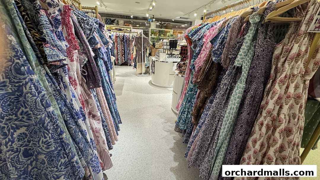 A wide selection of colorful, patterned dresses displayed on racks inside a boutique.