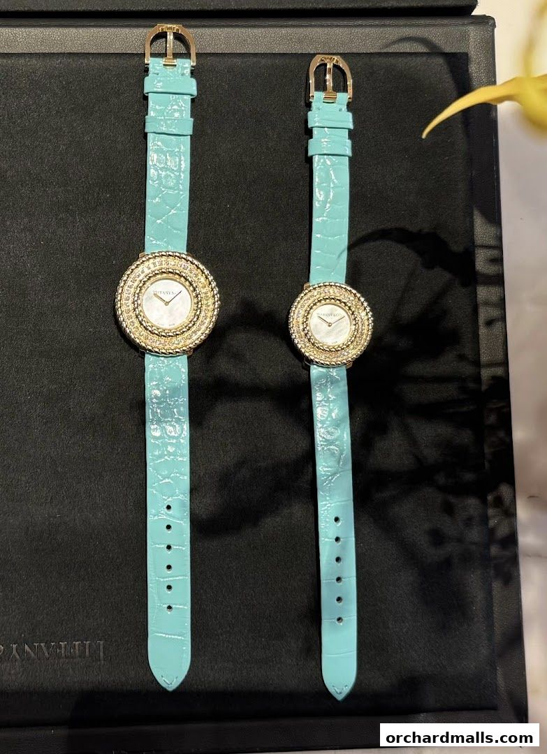 Two elegant Tiffany & Co. watches with turquoise alligator straps and diamond-encrusted bezels.